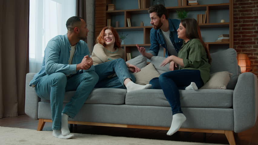 Group ethnic people friends talking discussing future plans at home meeting diverse multiracial women and men sit on comfortable sofa chatting friendly communication spending weekend together at home Royalty-Free Stock Footage #1100866827