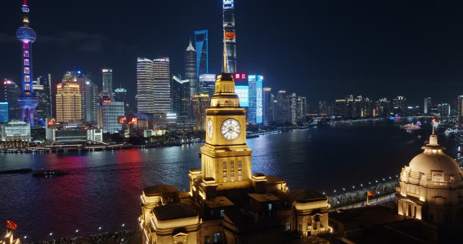 Drone footage of  The old Customs House and The bund in Shanghai at night,lujiazui in background.