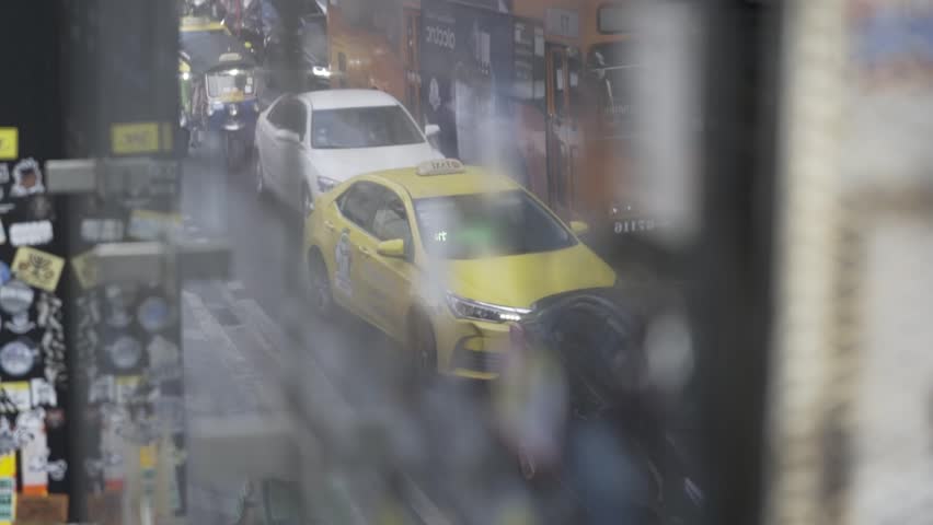 BANGKOK, THAILAND 2023: Traffic on Rama 1 Road with yellow taxis about to move. Royalty-Free Stock Footage #1100870453