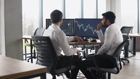 Two multiracial investors brokers analysing indexes online cryptocurrency stock. Diverse managers traders analysts discussing financial growth market at desk with pc graphs on screen - Powered by Shutterstock - Get 15% off with code: PIKWIZARD15