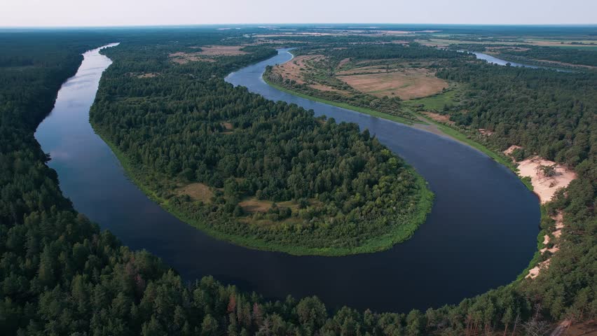 Beautiful aerial view of the countryside with fields and forests and numerous river bends in summer day