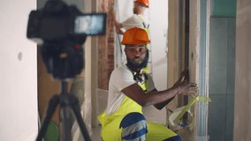 Blogging and renovation. Man recording video on camera at new home during repair and installation of walls. Builder blogger make video about house renovation. Realtime