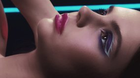 Vertical video. 90s beauty. Retro makeup. 2000s fashion. Closeup portrait of teen girl face with purple color eyeshadow pink lips artistic look posing in neon light on dark black. - Powered by Shutterstock - Get 15% off with code: PIKWIZARD15