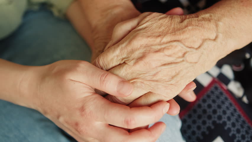 Close up hand of young woman or nurse home care holding senior grandmother give support empathy to elderly lady or older people in assisted living home care mental health relief concept. Royalty-Free Stock Footage #1100875565