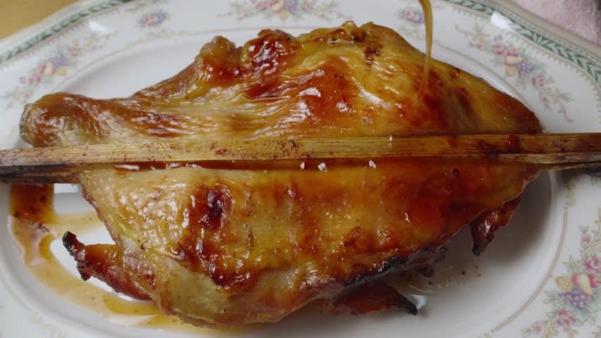 Close-up shot of famous street food grilled chicken on a stick, Thailand.