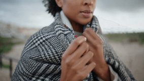 Closeup woman chest walking windy beach. African american hands adjusting scarf getting warm on cold weather. Calm beautiful woman strolling relaxing alone. Peaceful tourist feeling comfy on trip - Powered by Shutterstock - Get 15% off with code: PIKWIZARD15