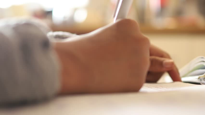 First person level view video of a girl hand writing in notebook on a desk. high quality video.  | Shutterstock HD Video #1100878603