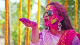 happy girl with sunglasses blowing holi colour powder from hand on flower decoration background - concept of holi festival celebration, Indian tradition and colourful culture - Powered by Shutterstock - Get 15% off with code: PIKWIZARD15