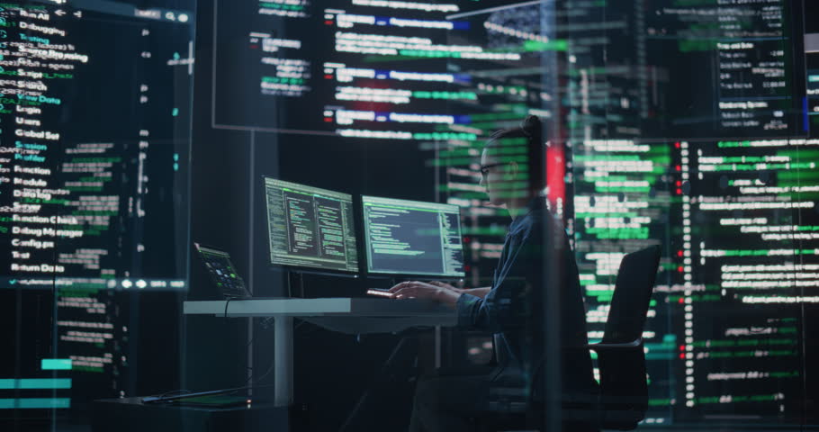 Dolly Shot of Female Programmer Working in a Monitoring Control Room, Surrounded by Big Screens Displaying Lines of Programming Language Code. Portrait of Woman Creating a Software and Coding Royalty-Free Stock Footage #1100883535
