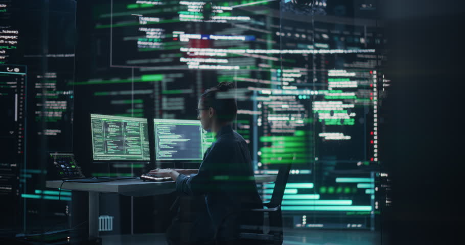 Dolly Shot of Female Programmer Working in a Monitoring Control Room, Surrounded by Big Screens Displaying Lines of Programming Language Code. Portrait of Woman Creating a Software and Coding Royalty-Free Stock Footage #1100883539