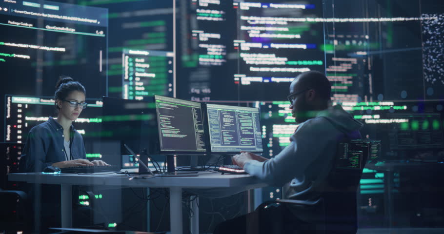 Portrait of Two Programmers Working in a Monitoring Control Room, Surrounded by Big Screens Displaying Lines of Programming Language Code. Portrait of Diverse Developers Creating a Software and Coding Royalty-Free Stock Footage #1100883641
