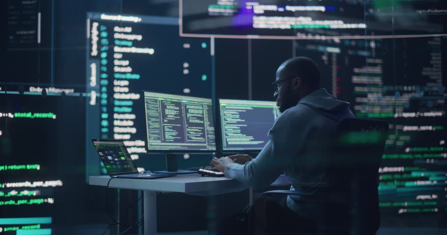 Portrait of a Black Man Working on Computer, Typing Lines of Code that Appear on Big Screens Surrounding him in Monitoring Room. Male Programmer Creating Innovative Software Using AI Data and System Royalty-Free Stock Footage #1100883649