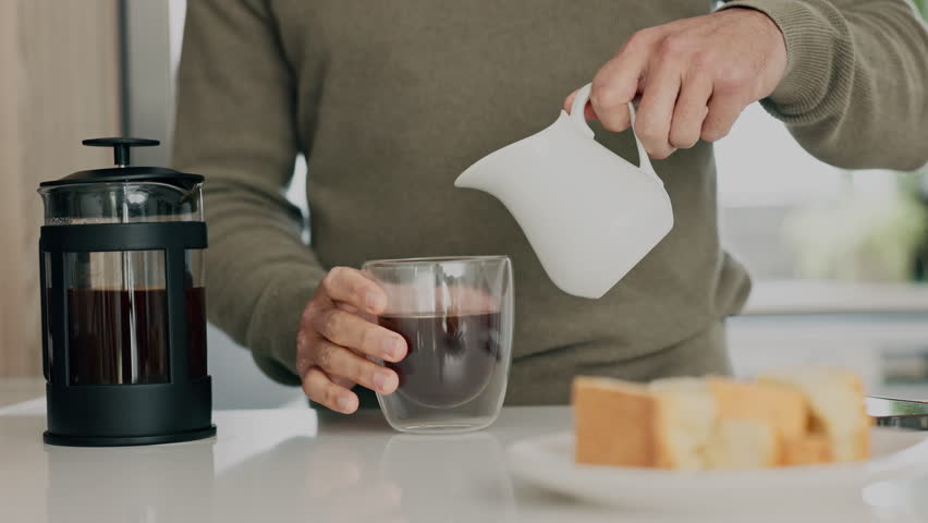 Coffee, dairy and milk pouring for breakfast drink in house kitchen to prepare strong cup of fresh plunger caffeine. Man hands, glass and morning of warm french press beverage to enjoy cappuccino