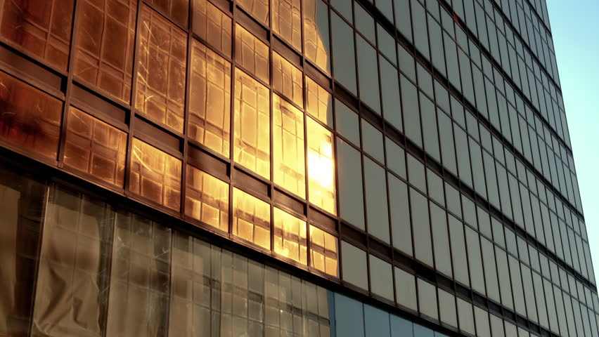 Golden walls of glass and steel doth the sun's rays cast their reflection.