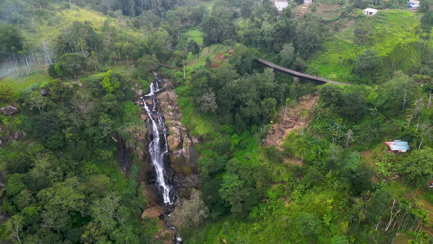 big waterfall and a train line bridge in the mountains of Ella, Sri Lanka