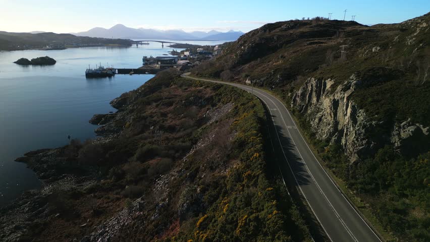 Deserted road to Kyle of Lochalsh with Skye bridge and Cuillin mountains in Scottish Highlands