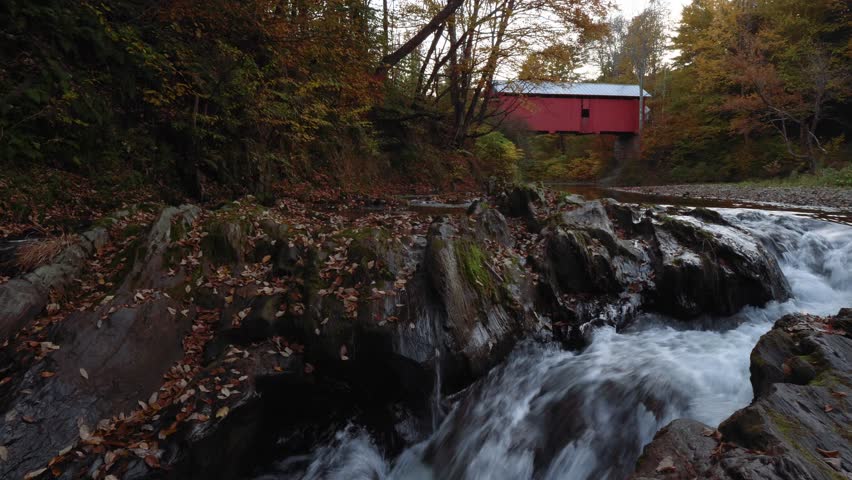 A covered bridge and a creek during fall in New England