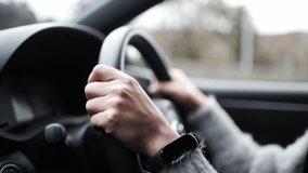 Hands of a woman driving and slow motion