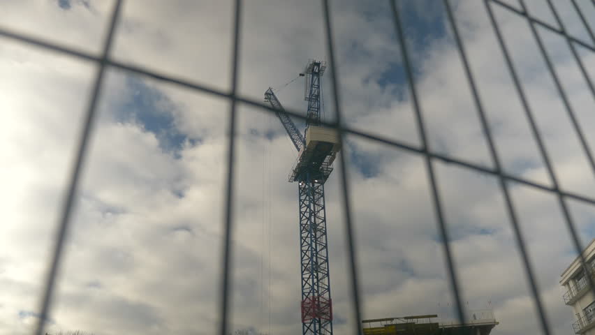 Construction Crane through Fence with Blue Sky