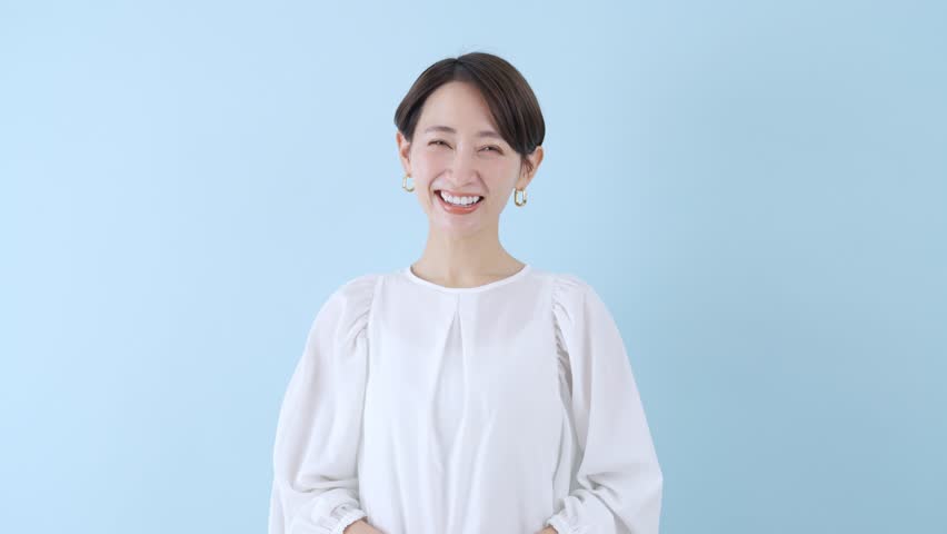Smiling woman with blue background | Shutterstock HD Video #1100899953