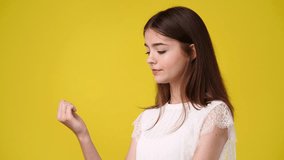 4k video of one girl who bites his nails because of her worries over yellow background.