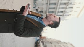 VERTICAL VIDEO: Man using map app on mobile phone