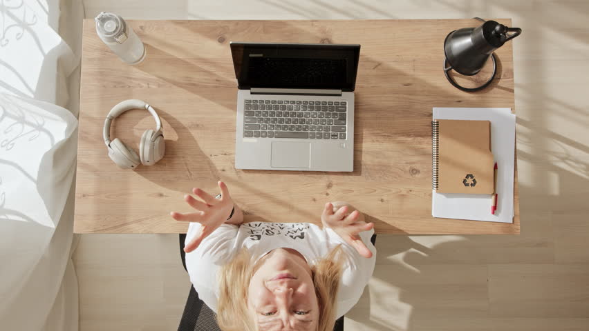 Top down view of girl working at computer and raising her hands up with emotion why. frustrated freelancer woman or office worker throws up her hand to sky and is indignant. | Shutterstock HD Video #1100905989