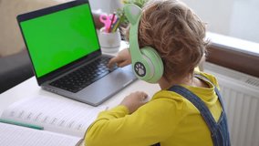 Schoolboy child headphones wireless hands typing keyboard using touchscreen laptop online educational programming lesson course at home. Distance learning remote video conference. Schoolgirl study