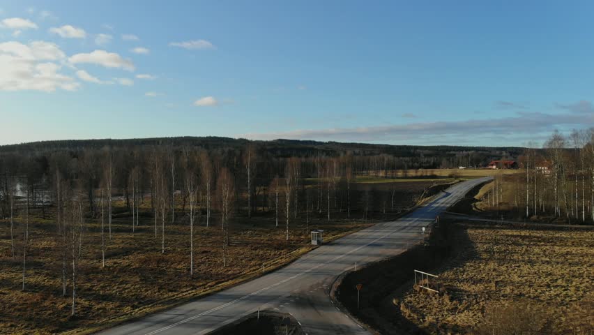 Drone footage of road in farmers landscape in Sweden.