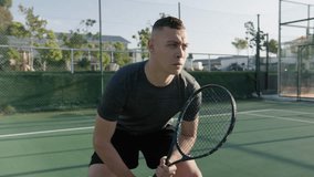 Focused young biracial man hitting tennis ball during tennis practice at sports court