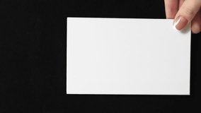 Vertical video. Mockup letter. Advertising card. Female hand showing blank white paper with empty space on black background loop. - Powered by Shutterstock - Get 15% off with code: PIKWIZARD15