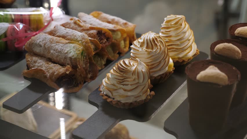 Various cakes on the counter in a modern cafe or pastry shop. Delicious fresh cakes in the pastry shop behind the glass.