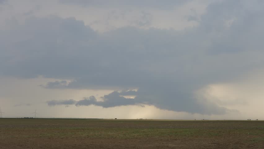 A storm looms over farm land in Kansas bringing much needed rain.