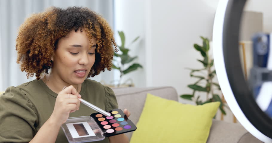 Black woman, cosmetics influencer and video tutorial with foundation palette, smile or beauty on social network. Gen z girl, digital makeup expert or online self care teaching for face product on web | Shutterstock HD Video #1100928807