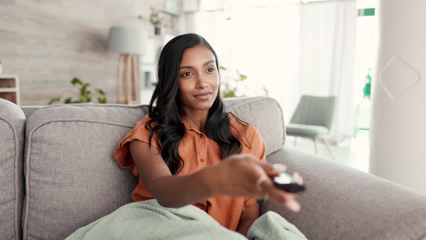 Black woman, remote control and sofa in home living room for watching tv, movies or streaming with excited face. Gen z girl, relax and comfort in house for movie, film or television on lounge couch | Shutterstock HD Video #1100929339