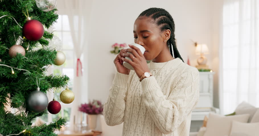Black woman, coffee and Christmas with smile for tree decorations, holiday and relax at home. Happy African American female enjoying drink and smiling for December festive season with decor indoors