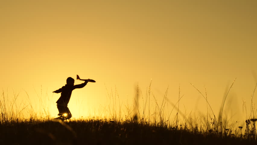 Happy Child boy plays with toy plane on field, sunset. Children play with toy airplane. Child boy wants to become pilot astronaut. Teenager dreams of flying, becoming pilot, Airplane flight. Childhood | Shutterstock HD Video #1100934269