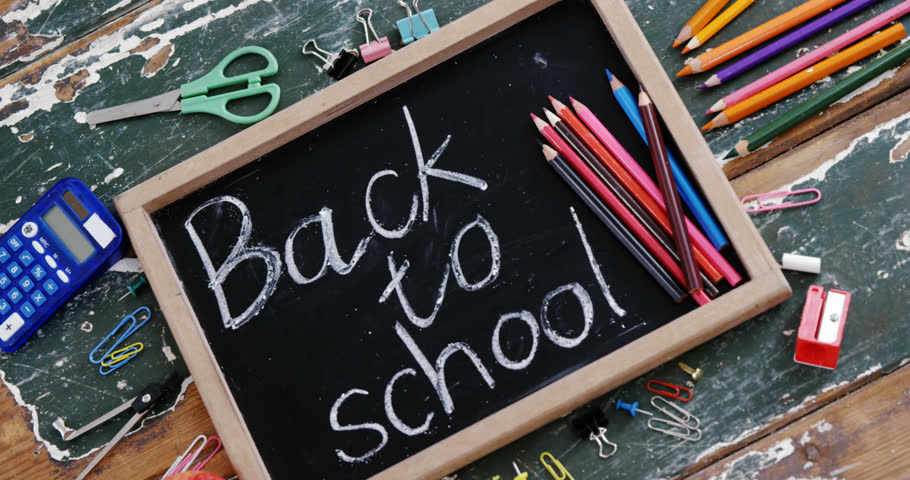 Animation of excited schoolboy and books moving over chalkboard with back to school text on desk. school, education and study concept digitally generated video.