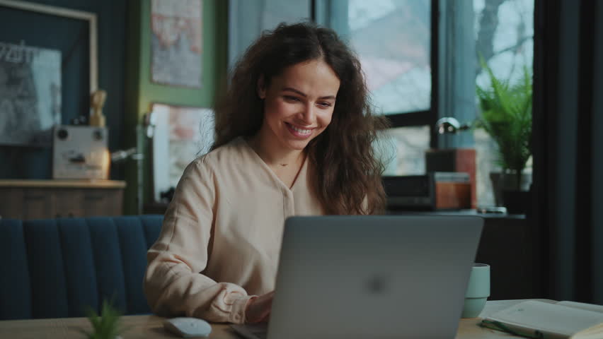 Footage of good-looking young smiling woman stylish dressed working on freelance platform. Portrait of beautiful girl enjoying online work from home. Remote job concept Royalty-Free Stock Footage #1100939489