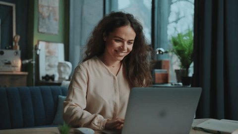 Footage of good-looking young smiling woman stylish dressed working on freelance platform. Portrait of beautiful girl enjoying online work from home. Remote job concept Video Stok