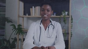 Animation of network of hexagons over african american female doctor. Global medicine, computing and data processing concept digitally generated video.