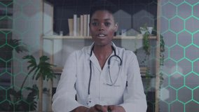 Animation of network of hexagons over african american female doctor. Global medicine, computing and data processing concept digitally generated video. - Powered by Shutterstock - Get 15% off with code: PIKWIZARD15
