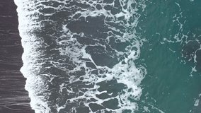4K aerial footage of high waves crashing into turquoise waters off the coast of Iceland.