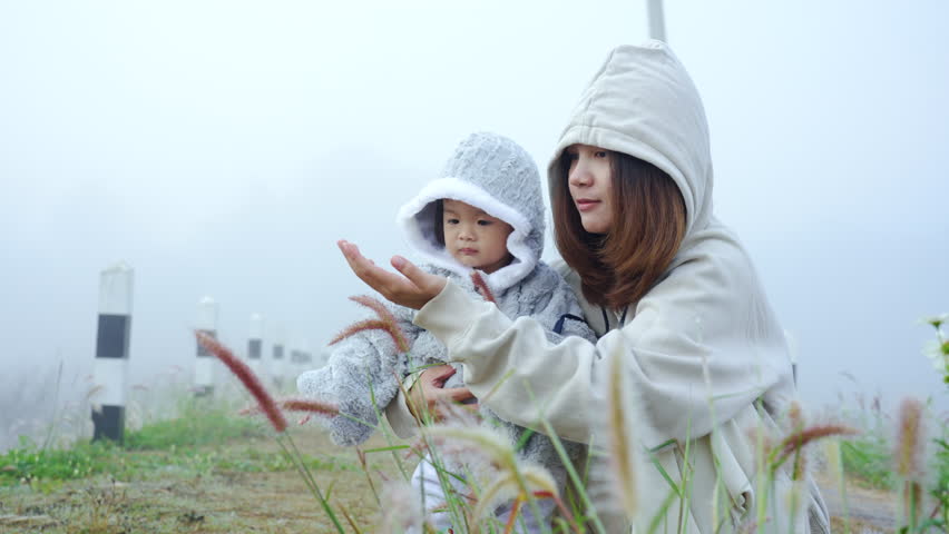 4K, eldest sister wrapped her little sister in her arms, both them wore thick hoodies with long sleeves hats, on a fine cold morning, there was a white fog covering the entire living area.