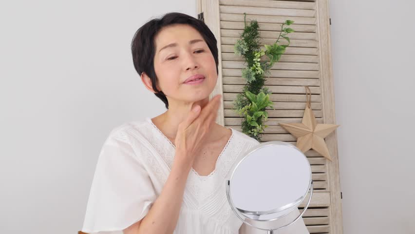 Asian middle aged woman taking care of her face skin