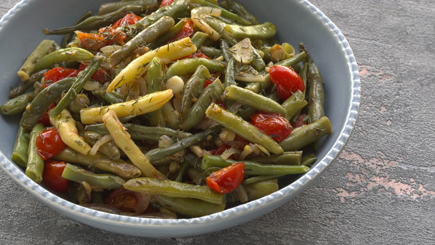 Mix of green beans and wax beans sauted with tomatoes, onion, garlic and dried thyme. Table spin.
