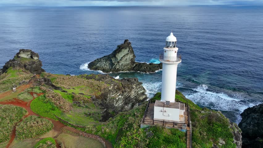 scenic seacoast with a lighthouse on Ishigaki Island, Okinawa, Japan, flying around lighthouse beacon on a cliff on an island in Pacific Ocean. High quality 4k footage