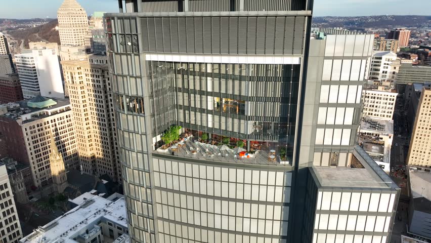 Aerial view of skyscraper in American city with beautiful amenities. Corporate office building in USA establishing shot from drone.