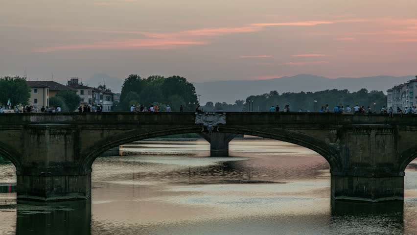 Twilight scene of Ponte Santa Trinita (Holy Trinity Bridge) day to night transition timelapse over River Arno with reflections on water after sunset. Close up view. Florence, Tuscany, Italy