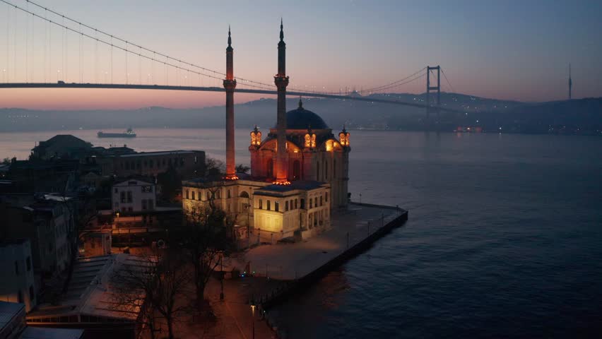 ORTAKOY, ISTANBUL, TURKEY. Aerial view of Istanbul. Ortakoy Mosque and Bosphorus Bridge (July 15 Martyrs Bridge) sunrise Bosphorus view. Drone shooting. Royalty-Free Stock Footage #1100960443